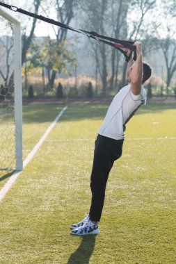 Genç adam trx askıları egzersiz Park yapmak