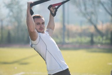 Trx Fitness askıları ile çekici bir adam eğitim