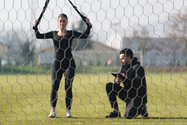 Genç çift trx askıları egzersiz Park yapmak