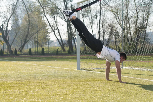 Vonzó férfi csinál Trx képzés hevederek Park — Stock Fotó