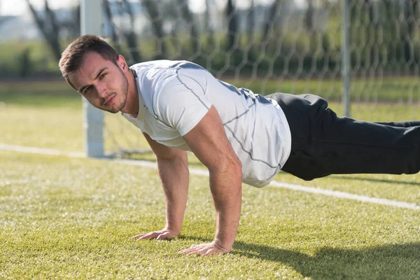 Junger Mann macht Liegestützgymnastik im Fitnessstudio — Stockfoto