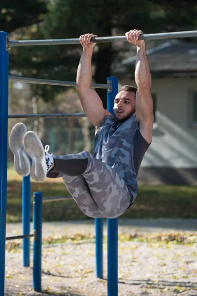 Homme attrayant exercice avec trempettes Bar dans le parc — Photo