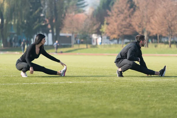 Coppia Runner Stretching Gamba in un Parco della Città — Foto Stock