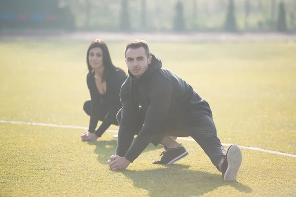 Esporte casal alongamento corpo no parque — Fotografia de Stock