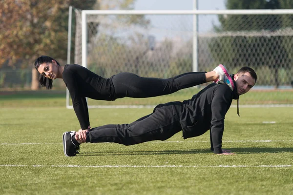 Casal fazendo treinamento Pushups na área do parque — Fotografia de Stock