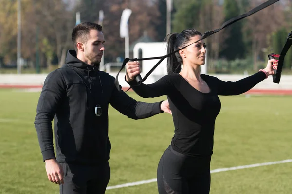 Genç çift trx askıları egzersiz Park yapmak