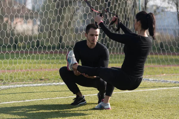 Atrakcyjna para szkolenie Trx Fitness paski — Zdjęcie stockowe