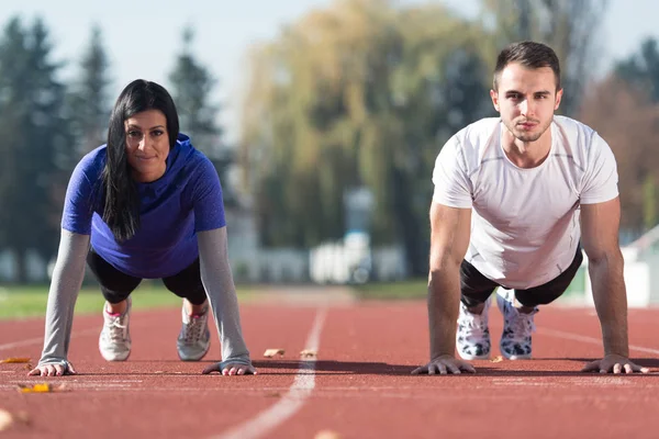 Couple Doing Pushups Training in Park Area