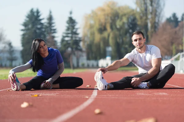 Onlar bacaklar açık havada çalıştırmadan önce genç çift Streching
