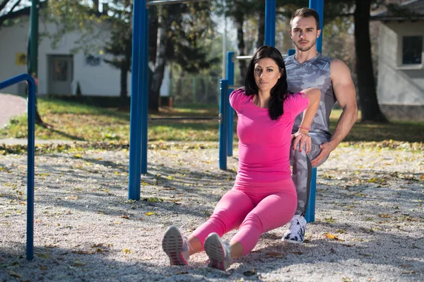 Jovem casal exercício com bar de mergulhos — Fotografia de Stock