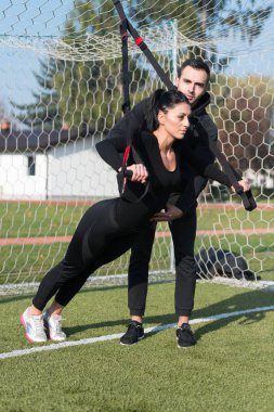 Genç çift trx askıları egzersiz Park yapmak