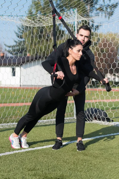 Genç çift trx askıları egzersiz Park yapmak