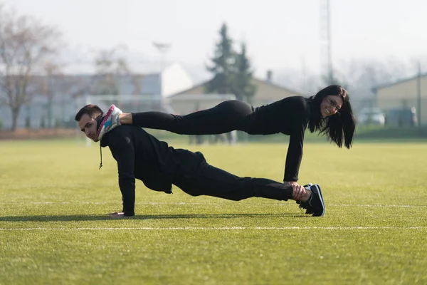 Jong koppel doen Push-up oefening in het Park — Stockfoto