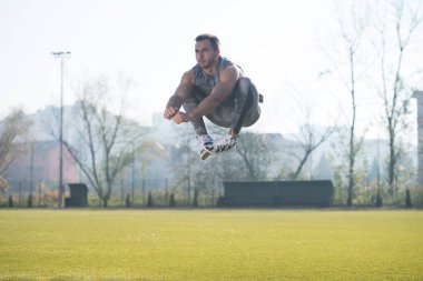 Genç adam bir atlama egzersiz dışında yapmak