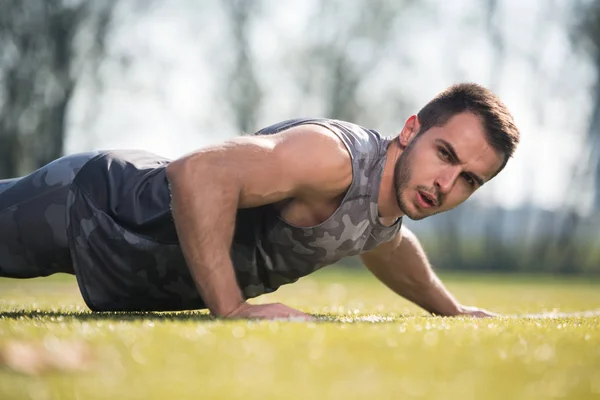 Uomo dello sport che fa flessioni nel parco — Foto Stock