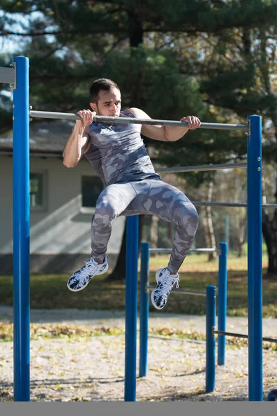 Jonge atleet uitoefenend met Bar Dips — Stockfoto