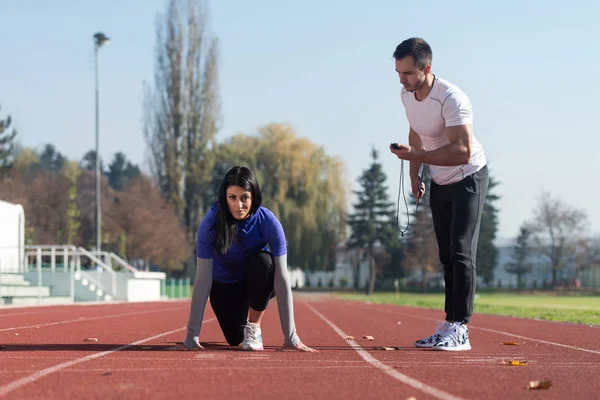 Atleta mulher pronta para iniciar a corrida de revezamento — Fotografia de Stock