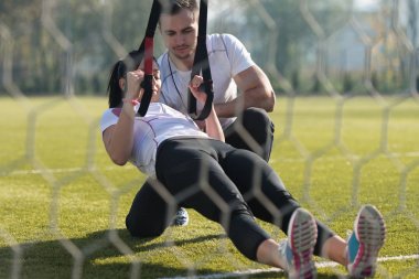 Genç çift trx askıları egzersiz Park yapmak