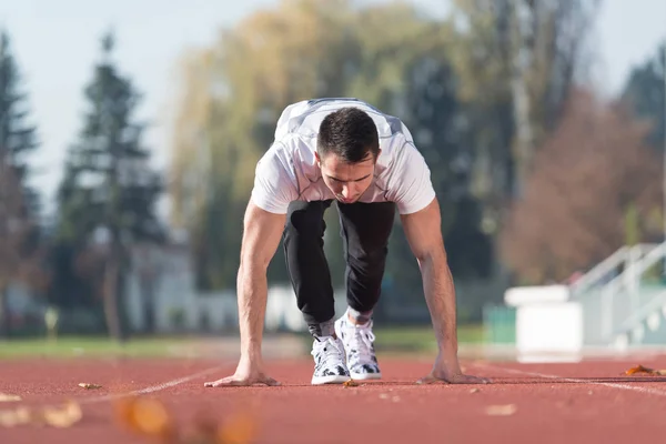 Uomo in piedi in posizione di partenza per correre — Foto Stock