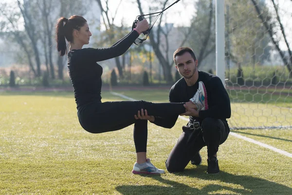 Genç çift trx askıları egzersiz Park yapmak — Stok fotoğraf