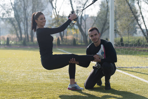 Young Couple Exercising Trx Straps in Park