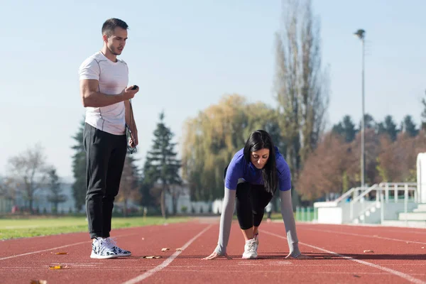 Mujer de pie en posición inicial para correr —  Fotos de Stock