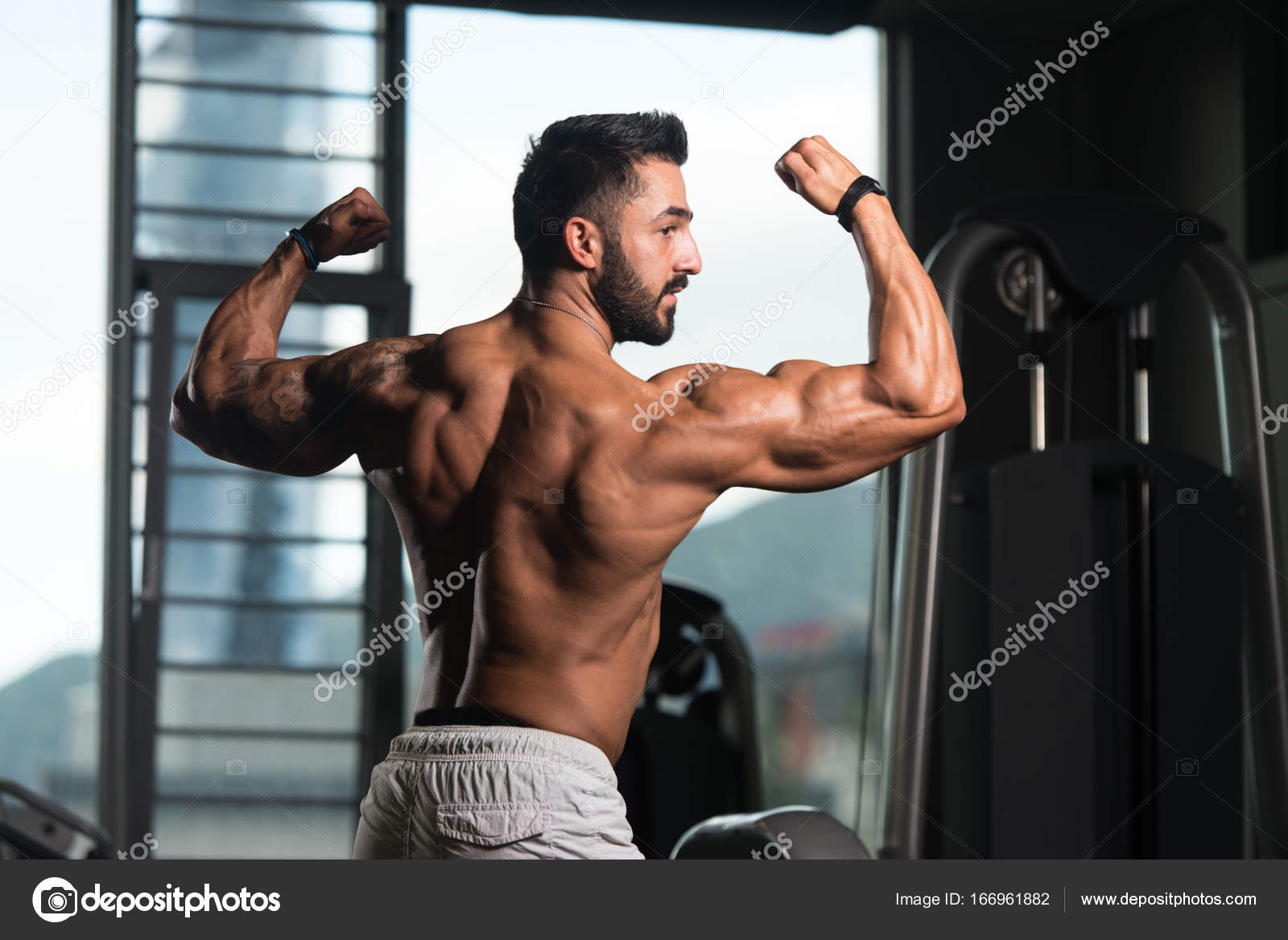 Muscular athletic bodybuilder fitness model posing after exercises in gym  Stock Photo