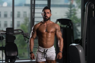 Yakışıklı kaslı adam içinde jimnastik salonu kas esneme