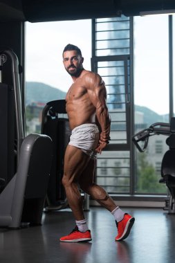 Yakışıklı kaslı adam içinde jimnastik salonu kas esneme