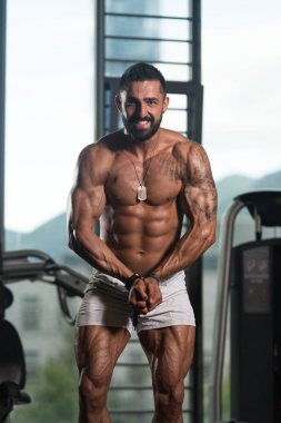 Yakışıklı kaslı adam içinde jimnastik salonu kas esneme