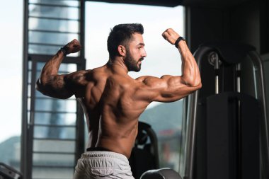 Vücut geliştirmeci Fitness Model çifte kol kası egzersizleri sonra poz