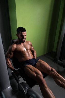 Yapan erkek bacak bukleler egzersiz spor salonunda oturmuş