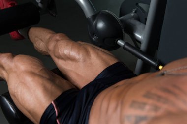 Yapan erkek bacak bukleler egzersiz spor salonunda oturmuş