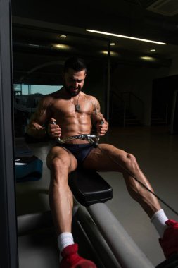 Kaslı adam arka için ağır egzersiz yaparak