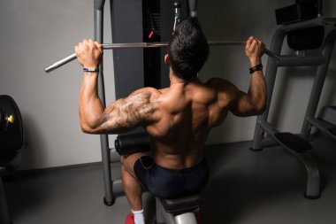 Kaslı adam arka için ağır egzersiz yaparak