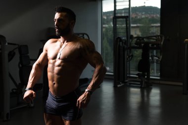 Yakışıklı kaslı adam içinde jimnastik salonu kas esneme