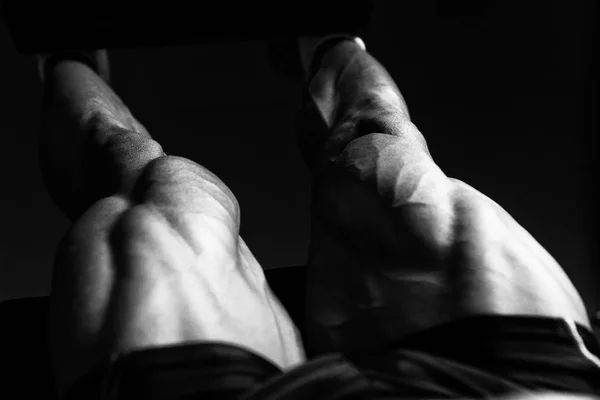 Hombre haciendo ejercicio sentado de los rizos de la pierna en el gimnasio — Foto de Stock