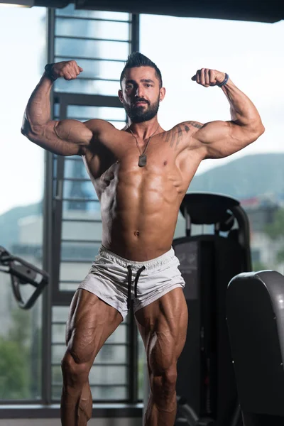 Vücut geliştirmeci Fitness Model çifte kol kası egzersizleri sonra poz