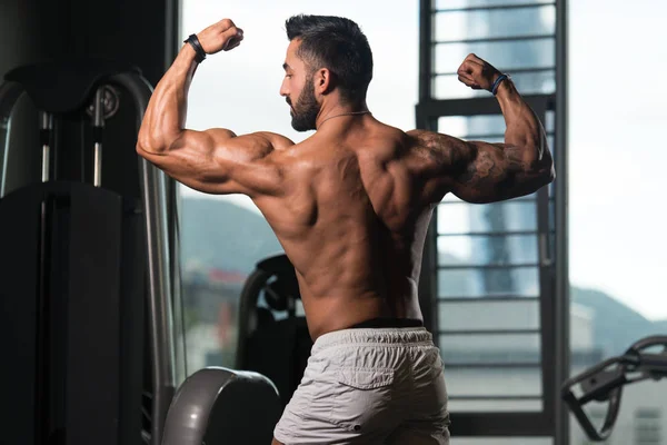 Muscular hombre flexión espalda músculos Pose — Foto de Stock