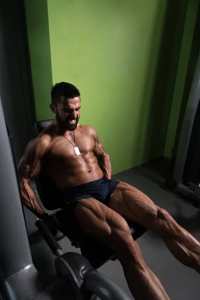 男子做坐腿卷发运动在健身房 — 图库照片