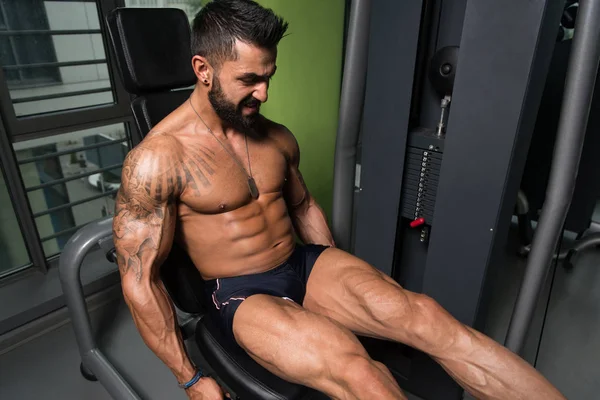 Yapan erkek bacak bukleler egzersiz spor salonunda oturmuş