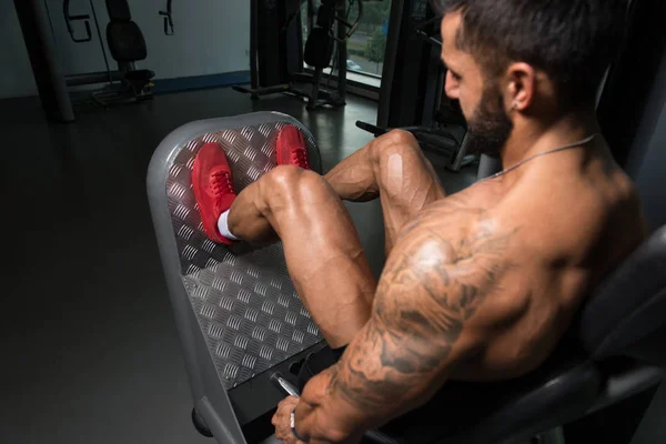 Hombre fuerte haciendo ejercicio de piernas en el gimnasio —  Fotos de Stock