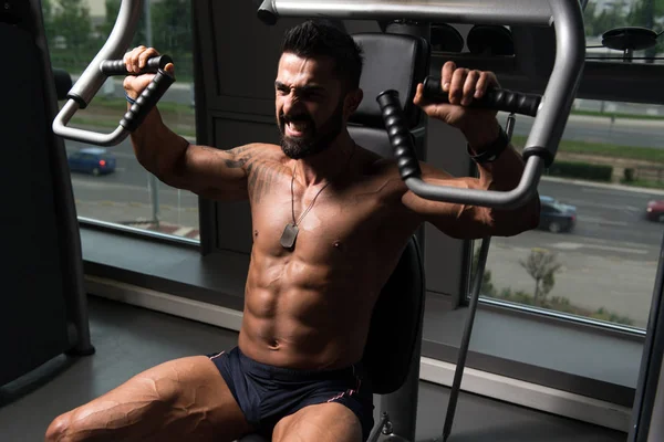 Kroppsbyggare tränar bröstet på maskin — Stockfoto