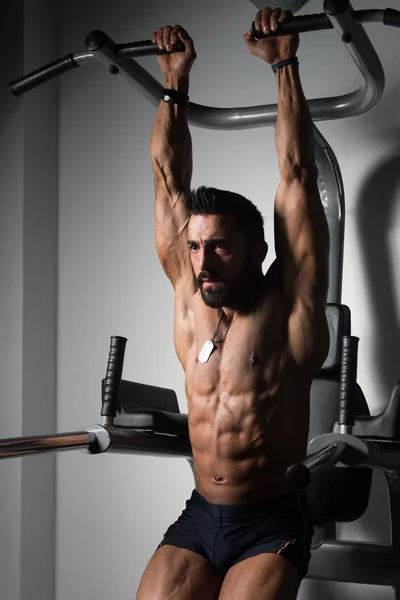 Mann macht Klimmzugstange Bauchgymnastik in Turnhalle — Stockfoto