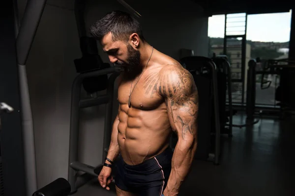 Seriöser Bodybuilder steht im Fitnessstudio — Stockfoto