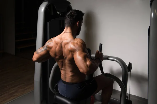 Atletisk Man gör övning för baksidan i gymmet — Stockfoto