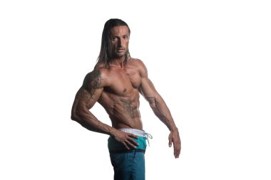 Beyaz arka plan üzerinde poz kaslı vücut geliştirmeci adam