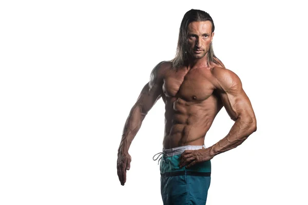 Gespierde Bodybuilder Man die zich voordeed op witte achtergrond — Stockfoto