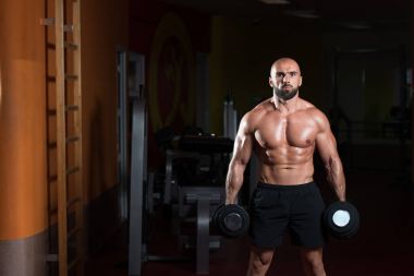Pazı egzersiz bir spor salonunda Dumbbells ile