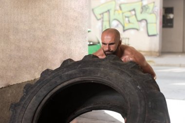 Kaslı adam lastik tarafından CrossFit egzersiz egzersiz çevir